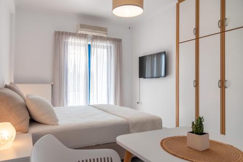 a bedroom with a bed and a table and a tv at Villa Rodanthi Sivota in Sivota