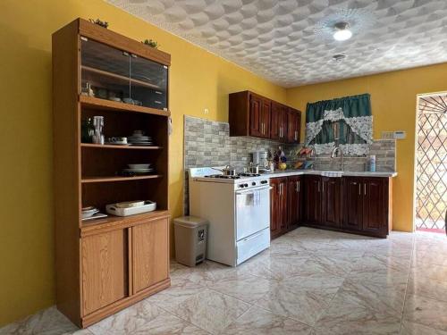 una cucina con pareti gialle e un piano cottura bianco con forno di Coolworthy Cozy Retreat a Mandeville