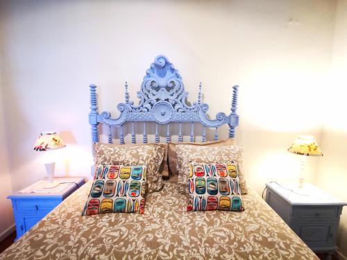 - un lit avec une tête de lit bleue et des oreillers dans l'établissement Charming Portuguese style apartment, for rent "Vida à Portuguesa", "Sardinha" Alojamento Local, à Portimão