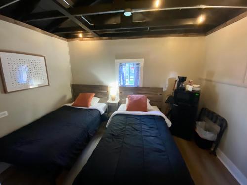 2 camas en una habitación pequeña con ventana en Cabin 9 at Horse Creek Resort, en Rapid City