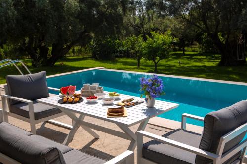a table with food on it next to a pool at Averto Villas with private pool in Nydri
