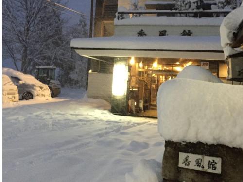 a house covered in snow in front of a house at Kofukan - Vacation STAY 67964v in Myoko