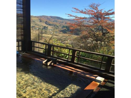 a bench on a porch with a view of a mountain at Kofukan - Vacation STAY 67964v in Myoko