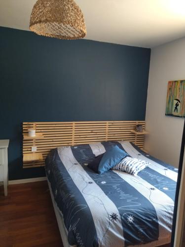 une chambre avec un grand lit avec un mur bleu dans l'établissement Maison calme 4 chambres 6 personnes proche mer et Golf La Baule, à Saint-André-des-Eaux