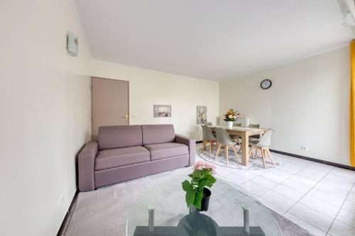 un salon avec un canapé et une table dans l'établissement Appartement moderne à 10 min de l'aéroport d'Orly, à Orly