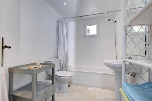 a white bathroom with a toilet and a sink at Puerto Banus Harbour View Apartment in Marbella