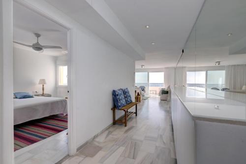 a white bedroom with a bed and a view of the ocean at Puerto Banus Harbour View Apartment in Marbella