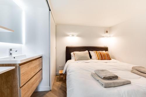 Dormitorio pequeño con cama y lavamanos en Zeezicht Villa Duin vlak bij strand en zee, en Bergen aan Zee