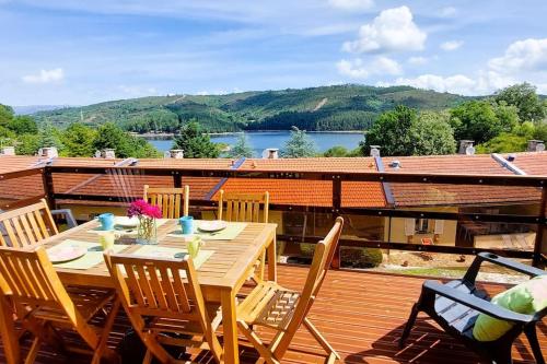 a wooden table and chairs on a deck at Casinha de Padrões in Venda Nova