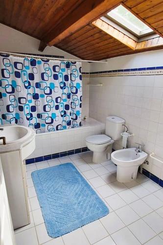 a bathroom with a toilet and a bidet and a sink at Casinha de Padrões in Venda Nova