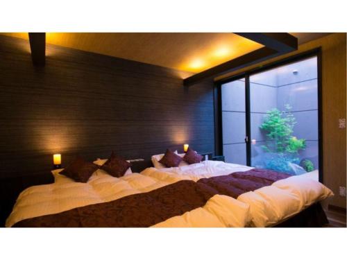 Oita Onsen Business Resort Sourin - Vacation STAY 73383v في أويتا: سرير كبير في غرفة مع نافذة كبيرة