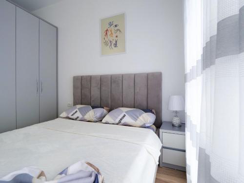 a bedroom with a large bed with white sheets and pillows at New and Comfy Studio with Mountain View at 'Mangalem21 Complex' in Tirana