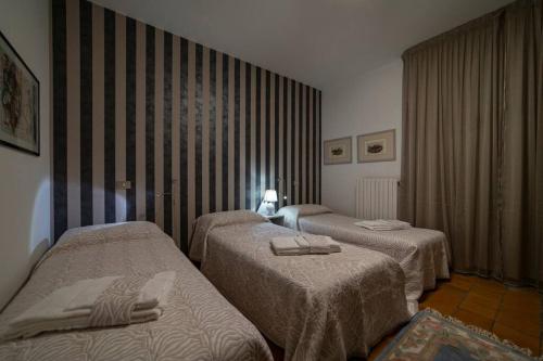 a hotel room with two beds and a window at Patio 15 - Pools, tennis and water sports in Iseo