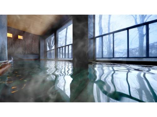 a room with a pool of water with windows at Sukayu Onsen Hakkoda Hotel - Vacation STAY 66848v in Aomori