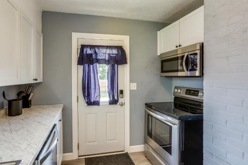a kitchen with a white door and a microwave at Dog-Friendly Port Clinton Home Walk to Lake Erie! in Port Clinton