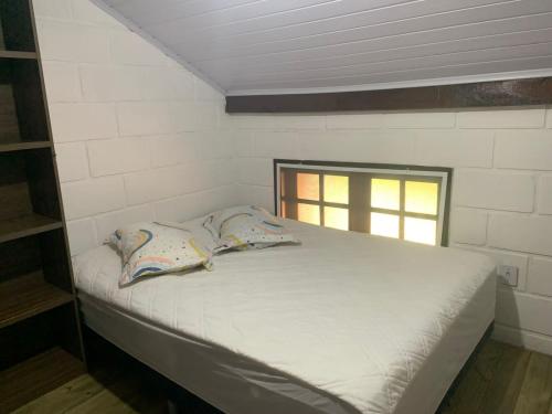 een klein bed in een kamer met een raam bij CHALÉ LAZER COMPLETO 700mts PRAIA in Ubatuba