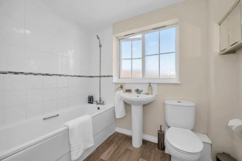 La salle de bains blanche est pourvue de toilettes et d'un lavabo. dans l'établissement The Grange Luxe3, à Ipswich