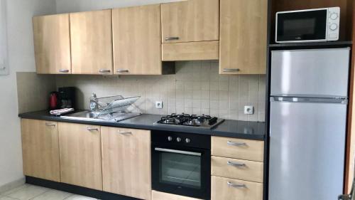 La cuisine est équipée d'un réfrigérateur, d'un évier et d'un four micro-ondes. dans l'établissement Appartement à 2 pas du Mont St-Michel, à Pontorson