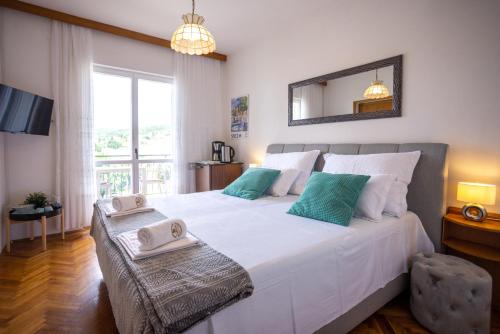 a bedroom with a large white bed and a window at Apartments Lonzor I in Selce
