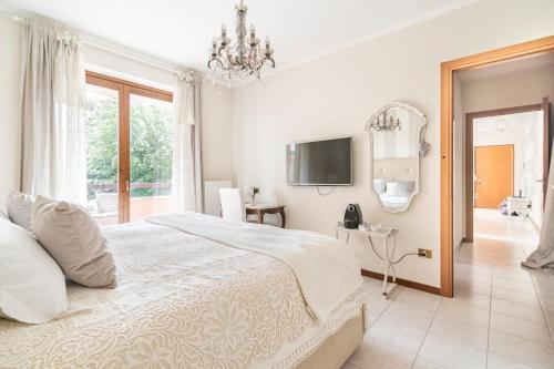 1 dormitorio blanco con 1 cama grande y TV en Fiorenza House, en Luisago