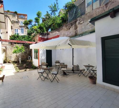 d'une terrasse avec des tables, des chaises et un parasol. dans l'établissement La Puteca, à Naples