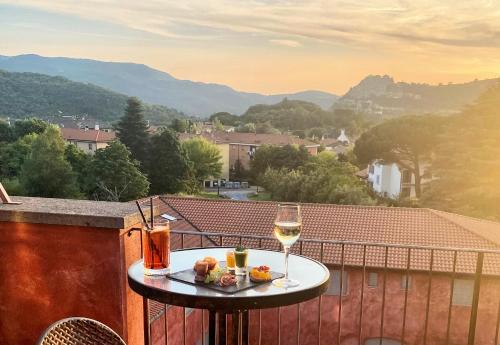 Grand Hotel Impero - Wellness & Exclusive SPA في كاستل ديل بيانو: طاولة مع كوب من النبيذ والطعام على شرفة