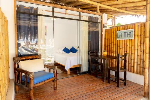 a room with a balcony with a bed and a table at Casa Lodge (primera fila) in Vichayito