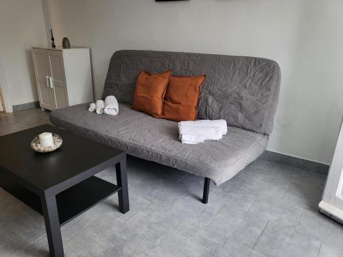 divano grigio con cuscini e tavolo in camera di Residenza Don Camillo a Mondello