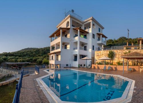 a hotel with a swimming pool in front of a building at Villa Rodanthi Sivota in Syvota