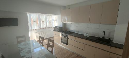 cocina con armarios blancos y encimera en Apartament 2 camere, en Râmnicu Vâlcea