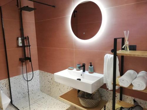 a bathroom with a sink and a shower and a mirror at Simά Apartments in Heraklio Town