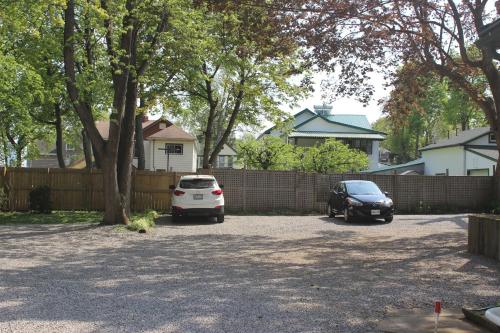 two cars parked in a driveway in front of a fence at Ellis House Bed & Breakfast in Niagara Falls