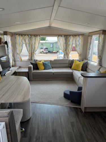 布里真德的住宿－Beautiful caravan in Trecco Bay! 74 sycomore，客厅配有沙发和桌子