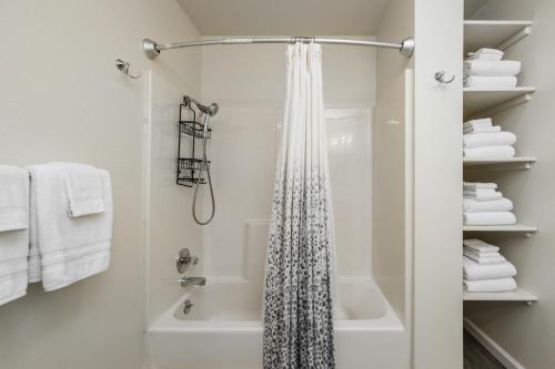 La salle de bains blanche est pourvue d'une douche et d'une baignoire. dans l'établissement Manor Getaway, à Anchorage