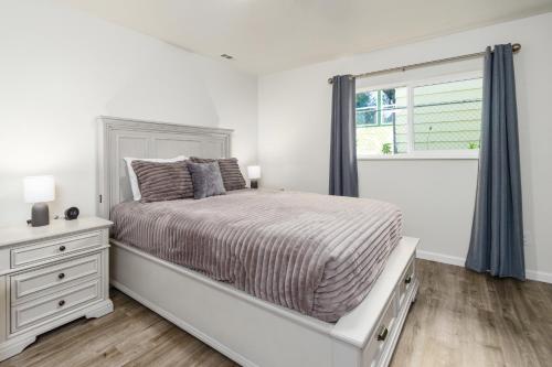 a white bedroom with a bed and a window at Manor Getaway in Anchorage