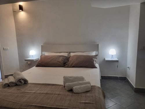 una camera da letto con un grande letto con due asciugamani di Residenza Don Camillo a Mondello