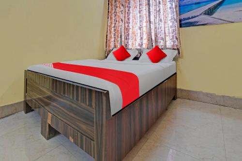 Bett mit roten Kissen in einem Zimmer in der Unterkunft Flagship The Hangout Residency Inn in Jamshedpur