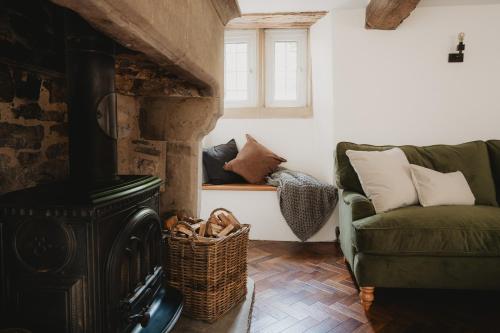a living room with a wood stove and a couch at Lodge Cottage, Castleton in Castleton