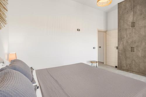 a white bedroom with a bed and a sliding door at Zana's Villas-Zenia in Akrotiri