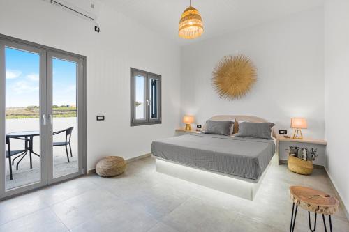 Dormitorio blanco con cama y mesa en Zana's Villas-Zenia en Akrotiri