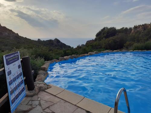 een zwembad met een bord ervoor bij Villetta Rocchi - Costa Paradiso in Costa Paradiso