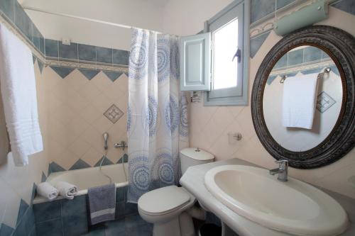 a bathroom with a sink and a toilet and a mirror at Joy Beach Ηotel in Perivolos