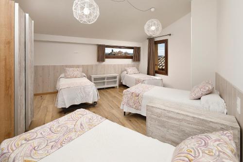 a room with three beds in a room at El Portal de Alquezar in Alquézar