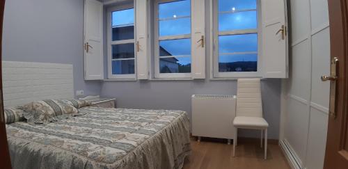 a bedroom with a bed and two windows at Entre Las Catedrales Campo y Mar 1 y 2 in Lourenzá