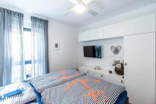 een slaapkamer met een bed met een oranje x op bij Apartman Joy in Banjole