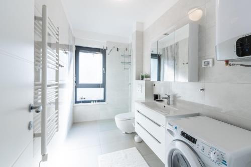 een witte badkamer met een wasmachine bij Apartman Joy in Banjole