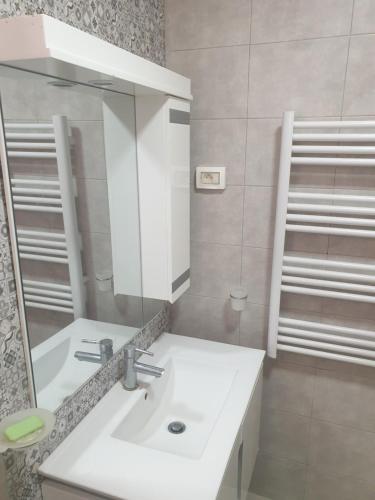 een badkamer met een witte wastafel en een spiegel bij Villa Château D'eau Djerba in Awlād ‘Umar