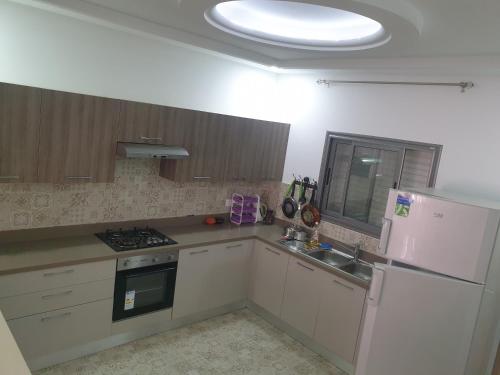 een keuken met een witte koelkast en een wastafel bij Villa Château D'eau Djerba in Awlād ‘Umar