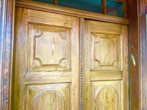 a pair of wooden doors in a building at CHATA OTWARTYCH OKIENNIC Pokoje Gościnne in Supraśl