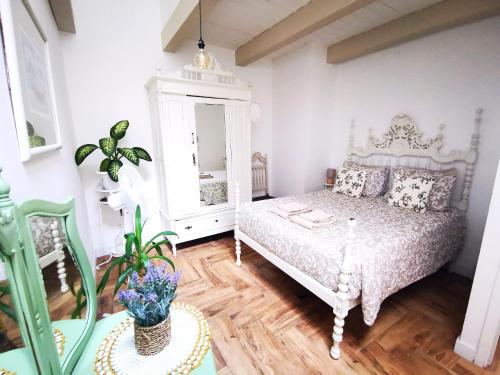 um quarto com uma cama branca e um espelho em Charming Portuguese style apartment, for rent "Vida à Portuguesa", "Gaivota" Alojamento Local em Portimão